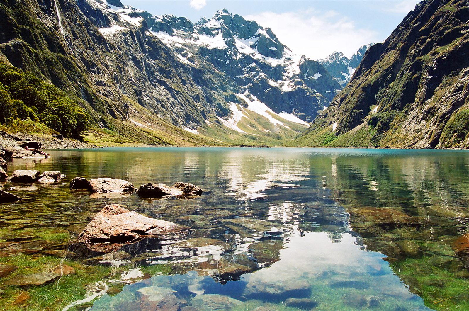 Snow-capped mountains reflected in a clear alpine lake